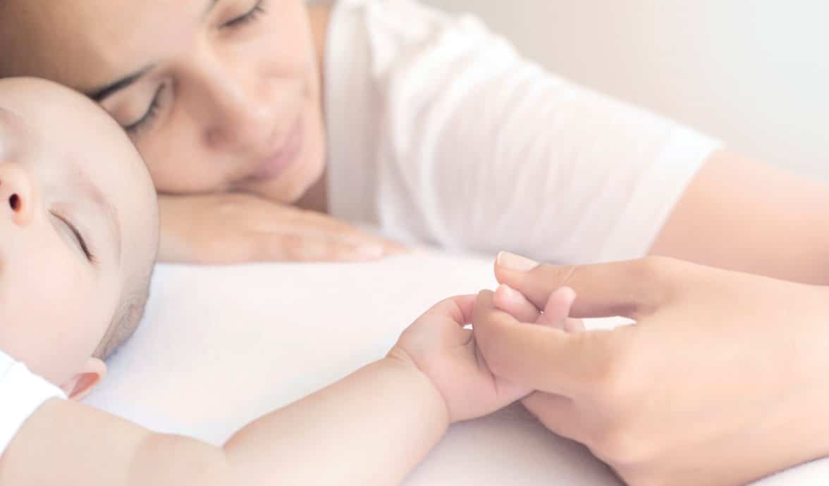 mãe segura a mão do seu bebê
