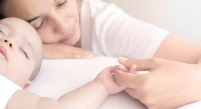 mãe segura a mão do seu bebê