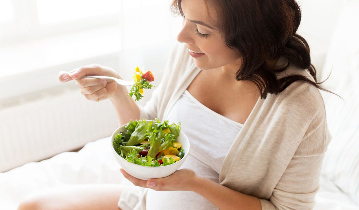Gestante de alimentando de salada com variedade de cores