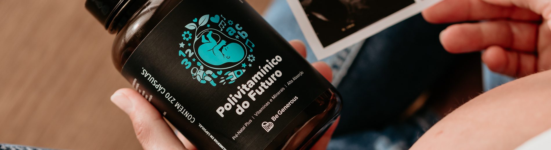 Imagem fechada do Polivitamínico do Futuro, um dos suplementos do projeto Be Generous enviado para Uruguaiana. Ele está na mão esquerda de uma gestante. A imagem está fechada na mão para mostrar o suplemento. É possível ver uma pequena parte da barriga da gestante que,na outra mão, segura uma imagem de ultrassom.